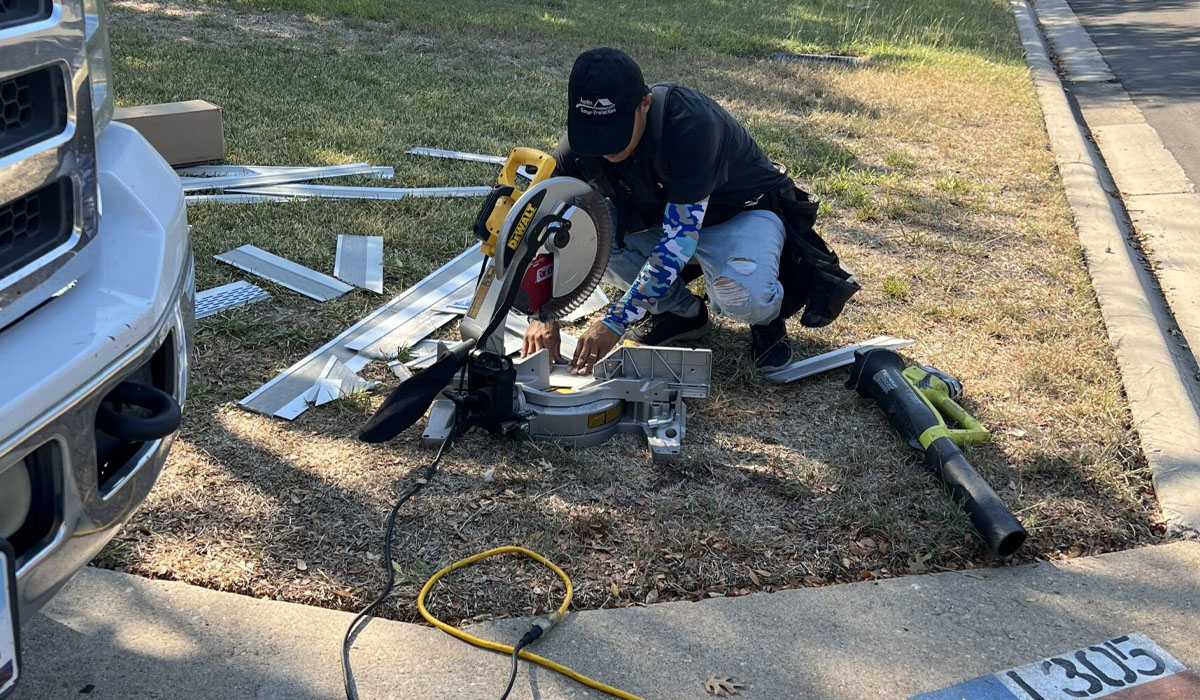 Austin gutter repair: a man using a chop saw to cut sections of a gutter