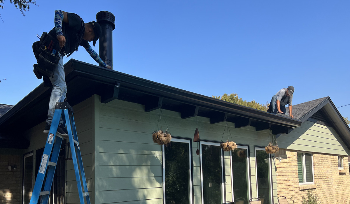 Two professional workers installing gutters
